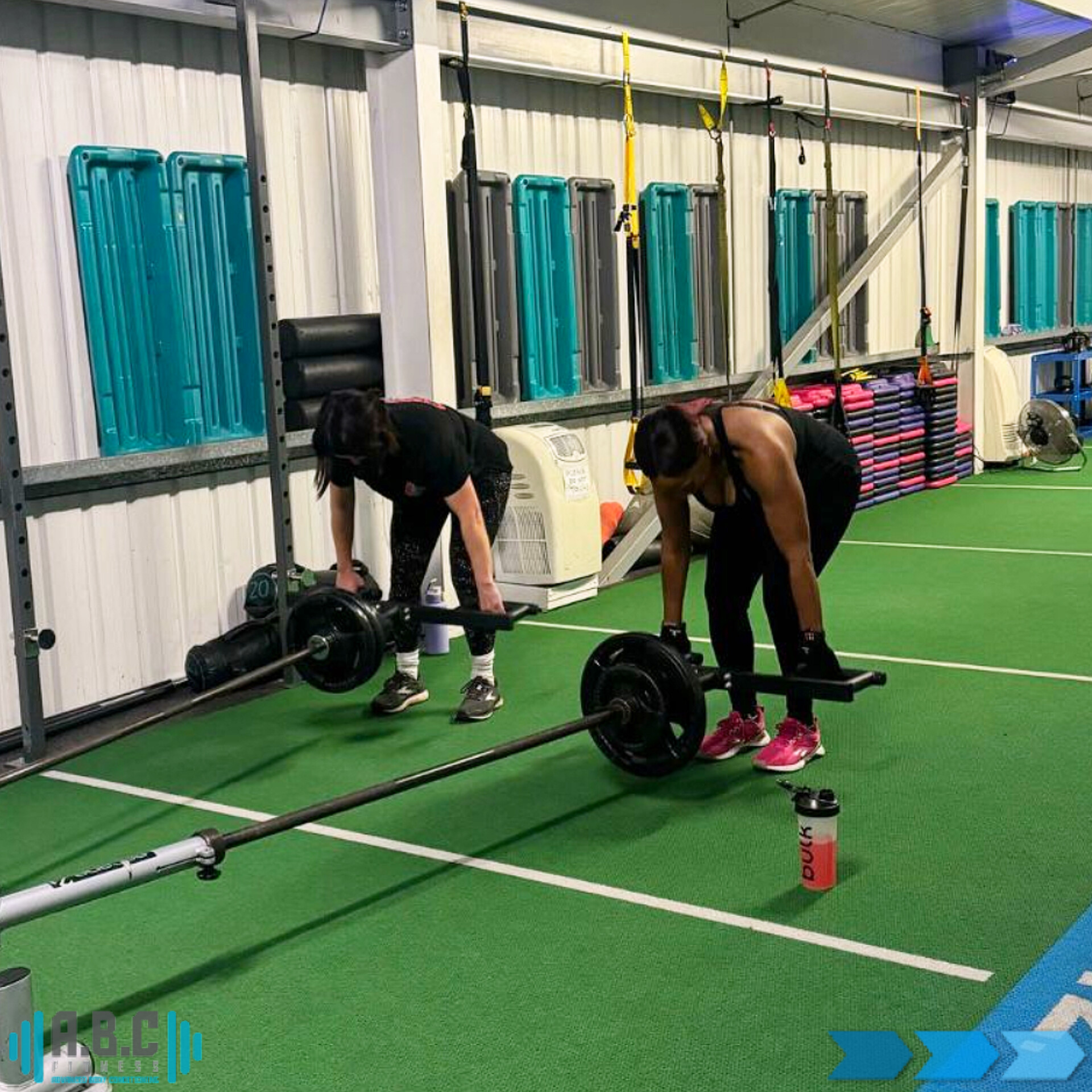 Two members lifting side by side at ABC Fitness in Eastwood